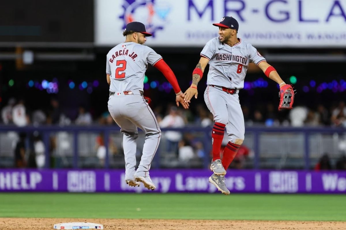 Apr 26, 2024; Miami, Florida, USA; Washington Nationals right fielder Eddie Rosario (8) and second baseman Luis Garcia Jr. (2) celebrate after the game against the Miami Marlins at loanDepot Park.