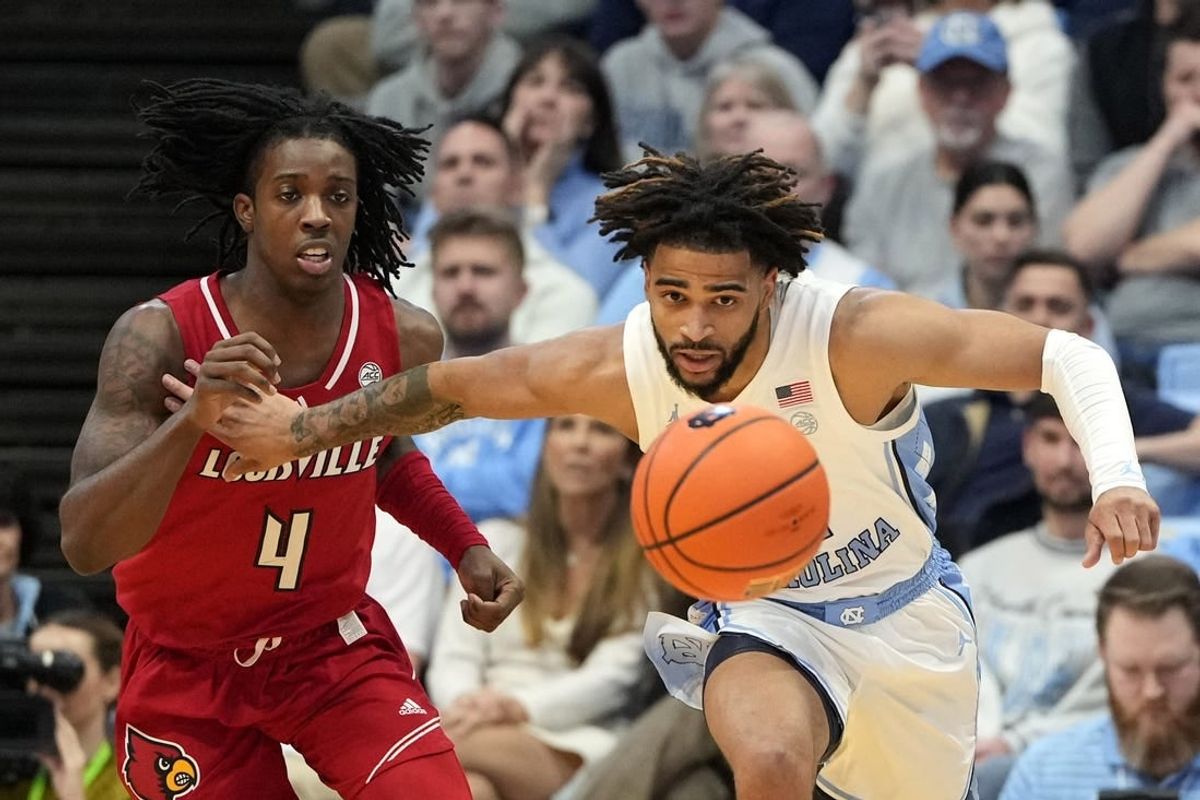 Jan 17, 2024; Chapel Hill, North Carolina, USA; Louisville Cardinals guard Ty-Laur Johnson (4) and North Carolina Tar Heels guard RJ Davis (4) fight for the ball in the first half at Dean E. Smith Center.