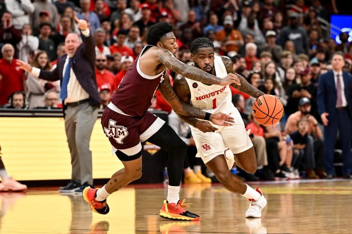 Dec 16, 2023; Houston, Texas, USA; Houston Cougars guard Jamal Shead (1) drives to the basket as Texas A&M Aggies guard Wade Taylor IV (4) defends during the second half at Toyota Center.