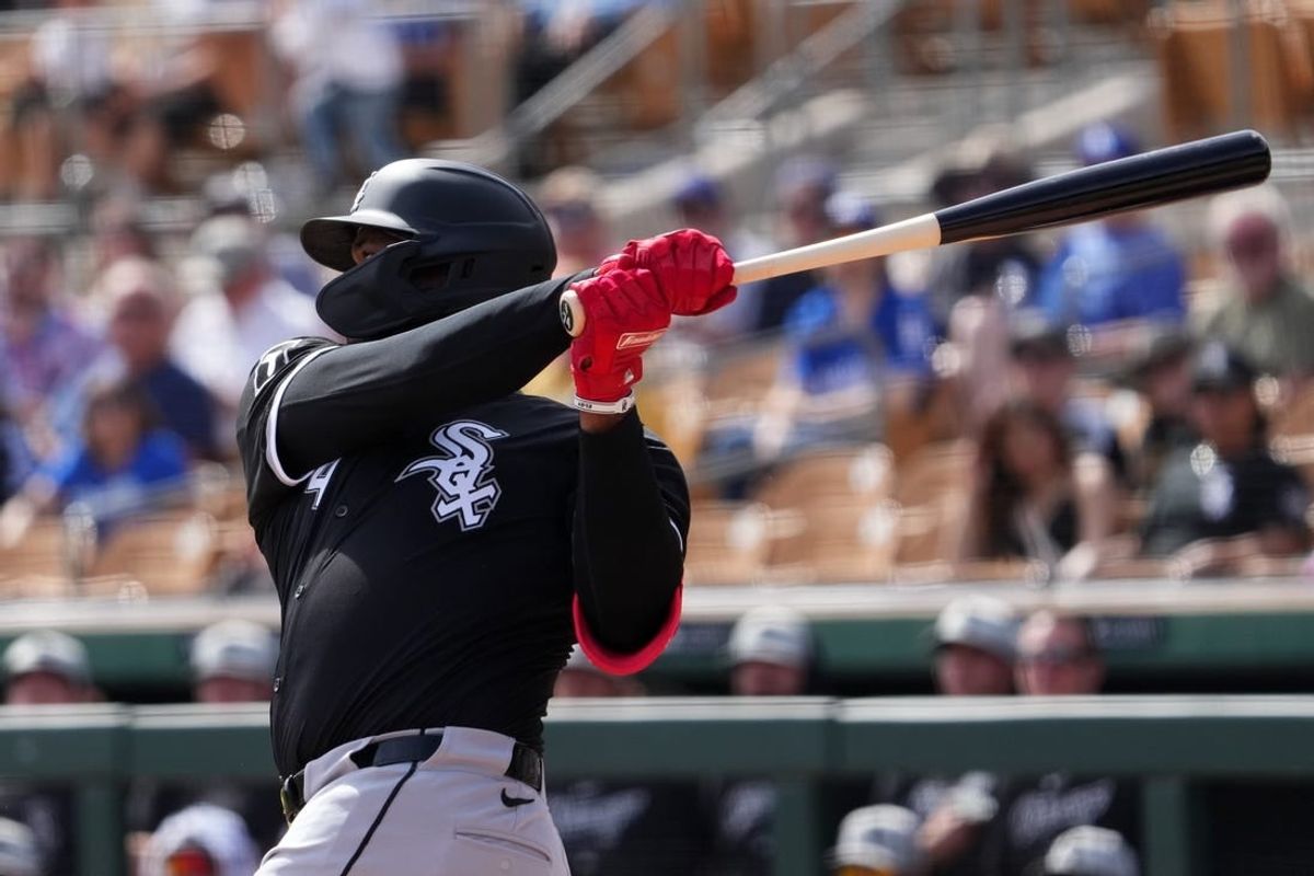 Feb 27, 2024; Phoenix, Arizona, USA; Chicago White Sox designated hitter Eloy Jimenez (74) hits an RBI double against the Los Angeles Dodgers during the first inning at Camelback Ranch-Glendale.