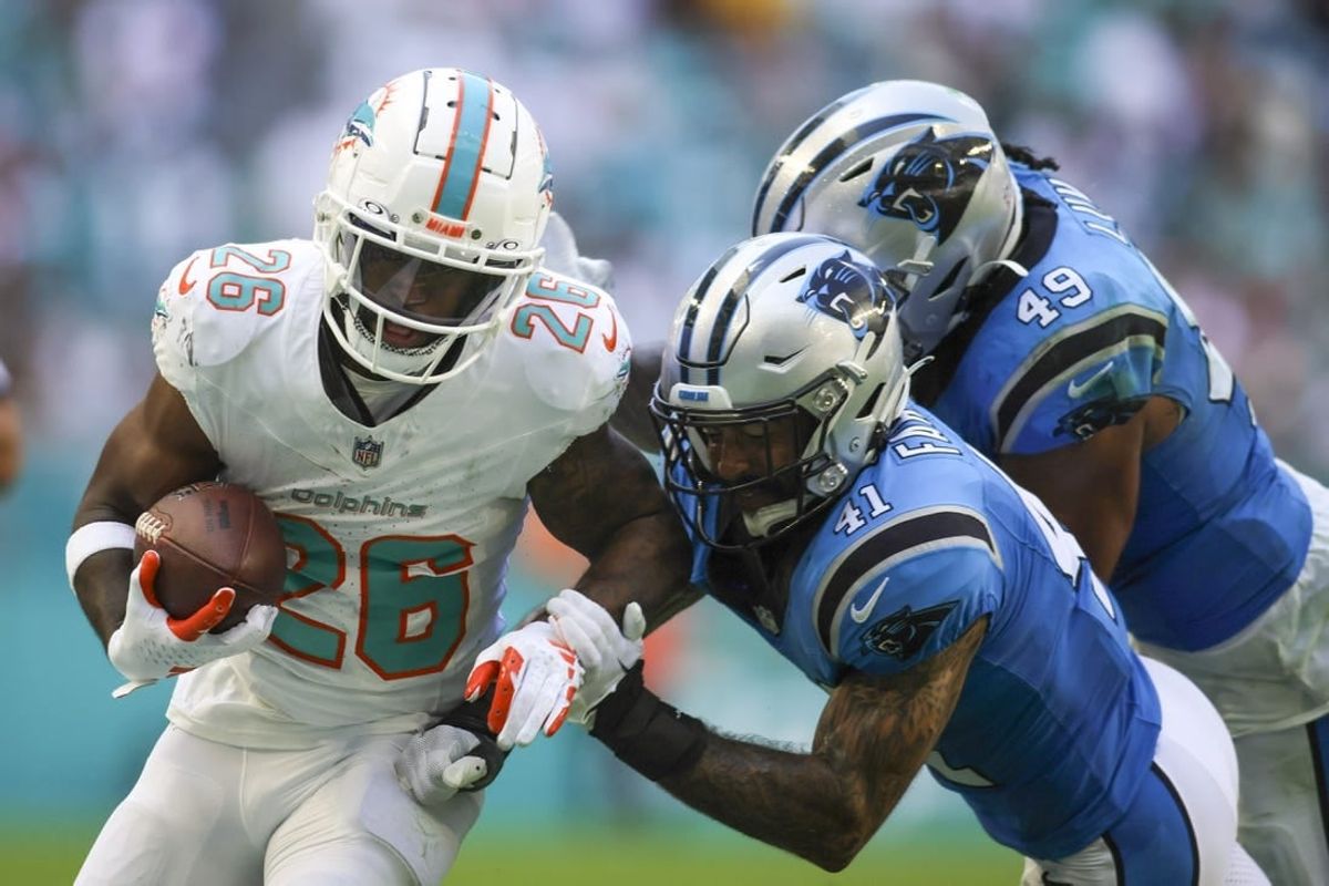 Oct 15, 2023; Miami Gardens, Florida, USA; Miami Dolphins running back De'Von Achane (28) runs with the football against Carolina Panthers safety Matthias Farley (41) during the fourth quarter at Hard Rock Stadium.