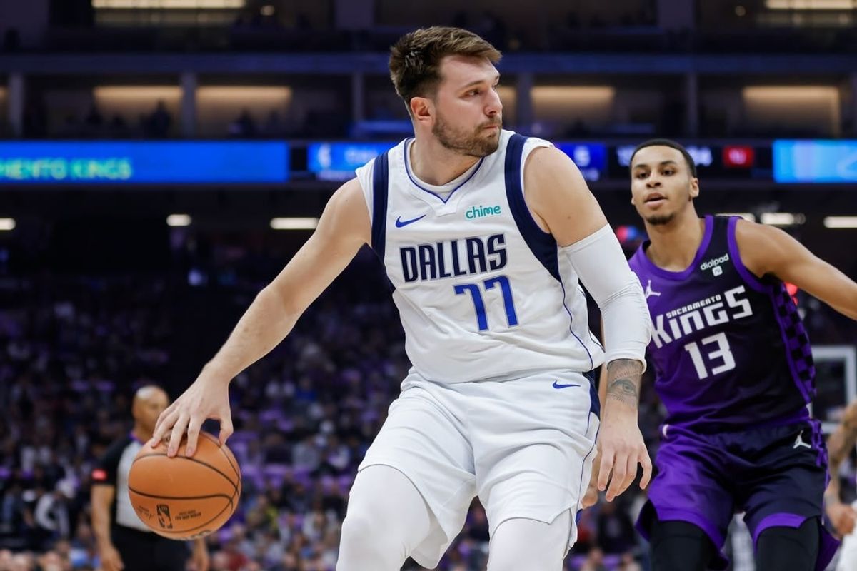 Mar 26, 2024; Sacramento, California, USA; Dallas Mavericks guard Luka Doncic (77) passes the ball against Sacramento Kings forward Keegan Murray (13) during the first quarter at Golden 1 Center.