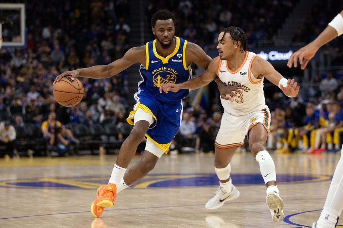 Mar 9, 2024; San Francisco, California, USA; Golden State Warriors forward Andrew Wiggins (22) tries to drive around San Antonio Spurs guard Tre Jones (33) during the second quarter at Chase Center.