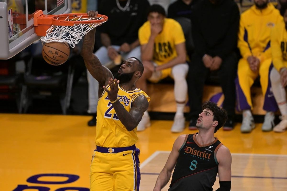 Feb 29, 2024; Los Angeles, California, USA;  Los Angeles Lakers forward LeBron James (23) moves past Washington Wizards forward Deni Avdija (8) for a dunk in the first half at Crypto.com Arena.