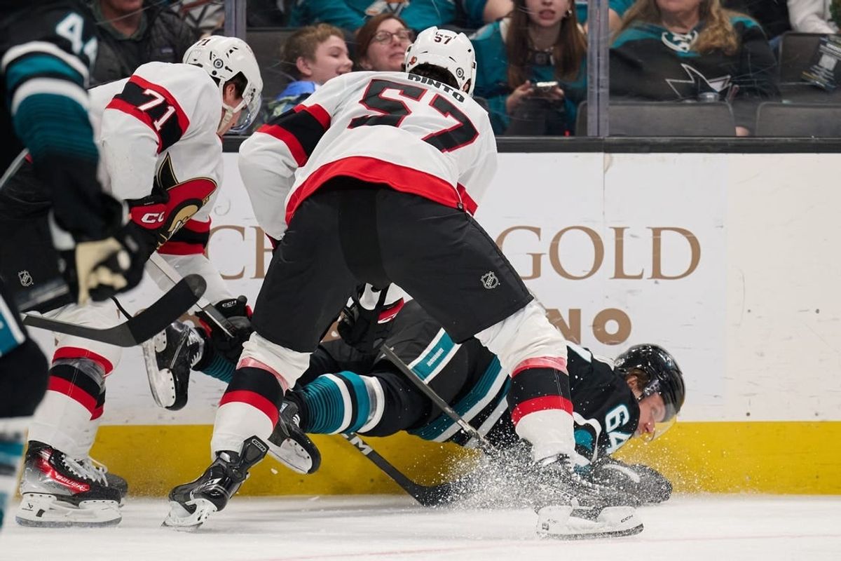 Mar 9, 2024; San Jose, California, USA: Ottawa Senators center Shane Pinto (57) and defenseman Nikolai Knyzhov (71) check San Jose Sharks center Mikael Granlund (64) to the ice during the first period at SAP Center at San Jose.