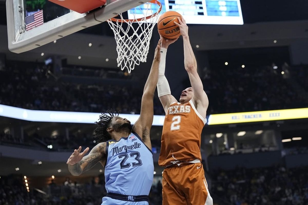 Dec 6, 2023; Milwaukee, Wisconsin, USA;  Texas Longhorns guard Chendall Weaver (2) shoots over Marquette Golden Eagles forward David Joplin (23) during the first half at Fiserv Forum.