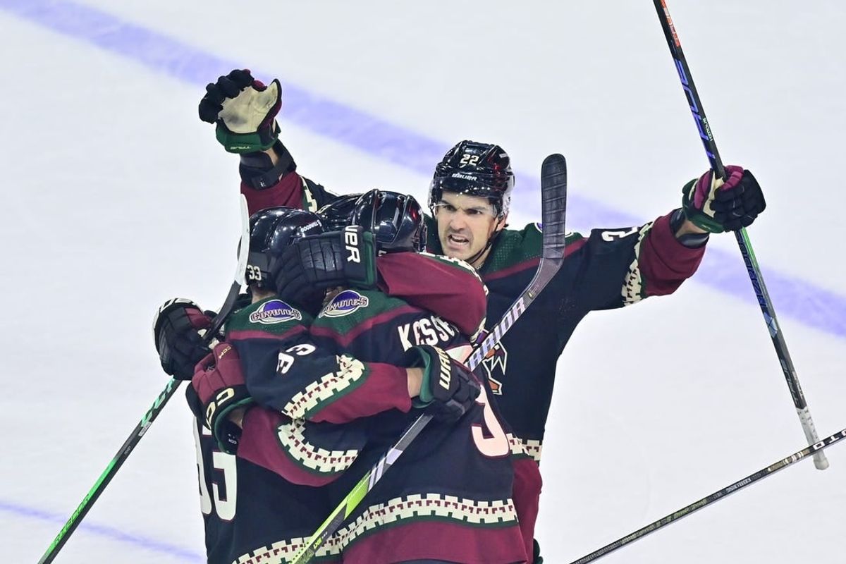 Dec 19, 2023; Tempe, Arizona, USA; Arizona Coyotes defenseman Michael Kesselring (5) celebrates with center Jack McBain (22) and defenseman Travis Dermott (33) after scoring a goal in the third period against the Ottawa Senators at Mullett Arena.