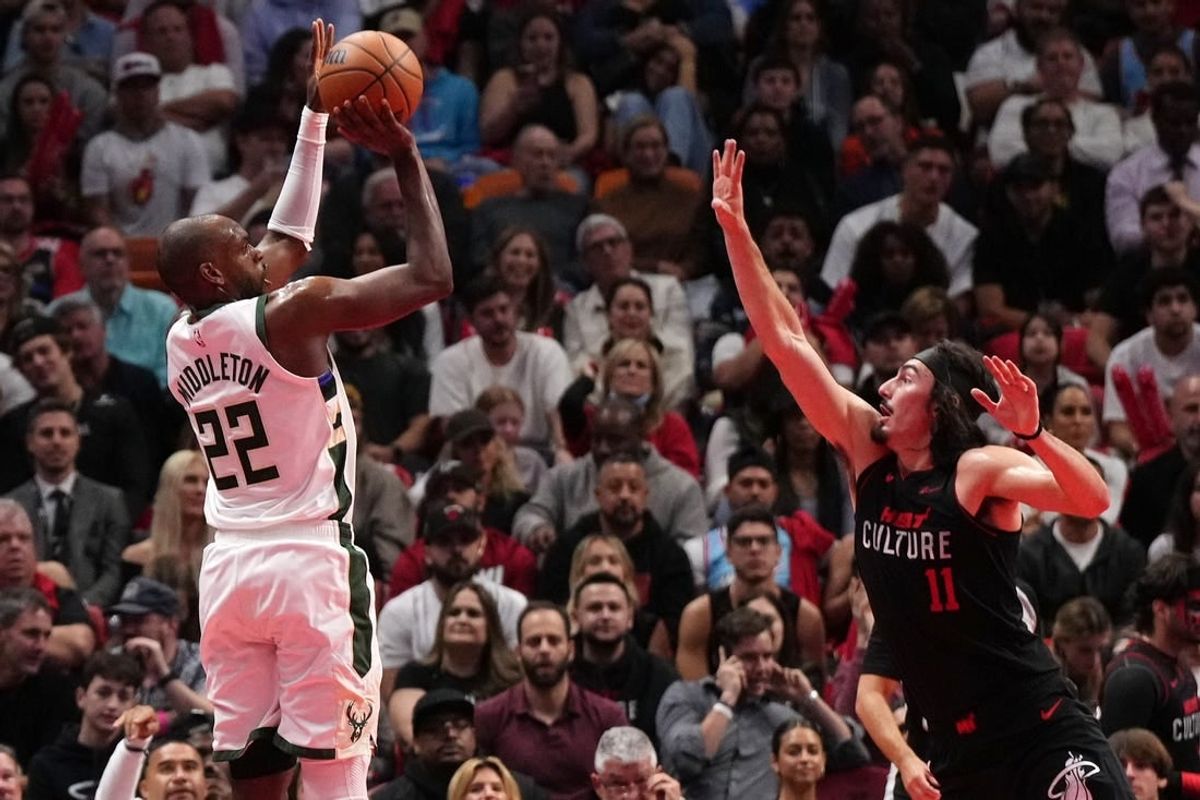 Nov 28, 2023; Miami, Florida, USA; Milwaukee Bucks forward Khris Middleton (22) shoots over Miami Heat guard Jaime Jaquez Jr. (11) during the first half at Kaseya Center.