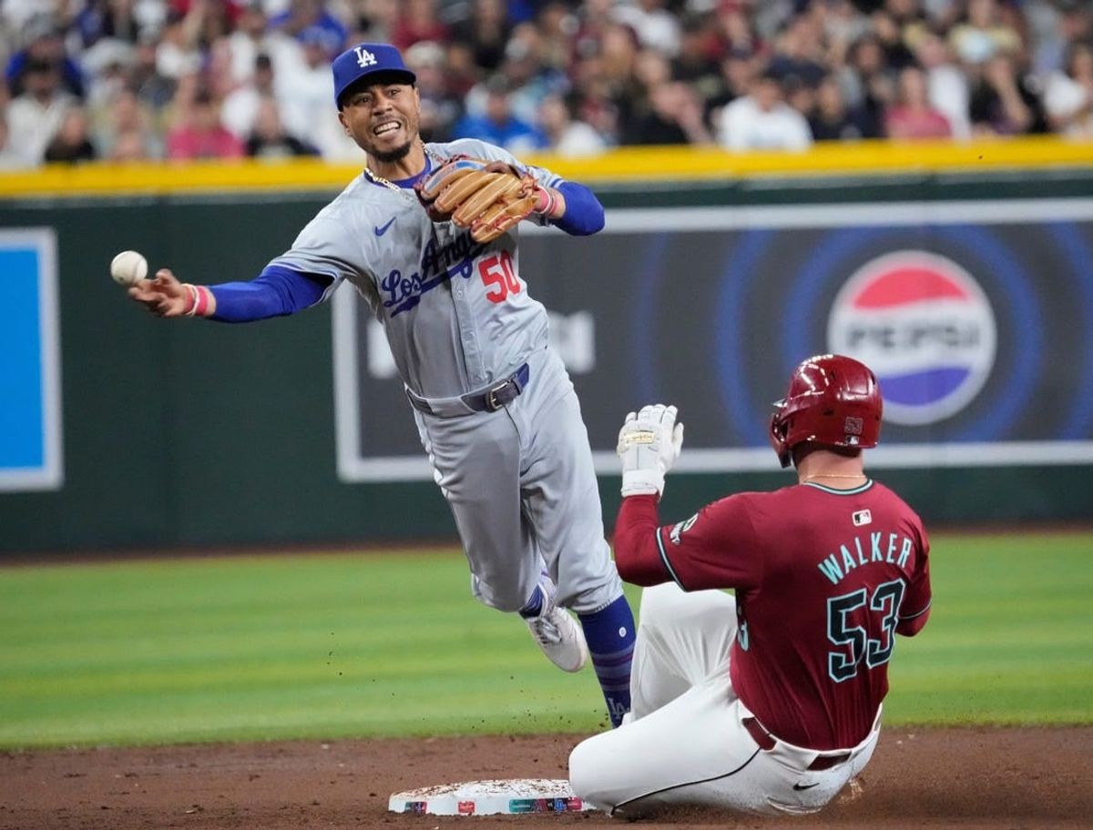 Los Angeles Dodgers shortstop Mookie Betts (50) throws to first after forcing out Arizona Diamondbacks’ Christian Walker (53) on a double play during the third inning at Chase Field on Monday, April 29, 2024.