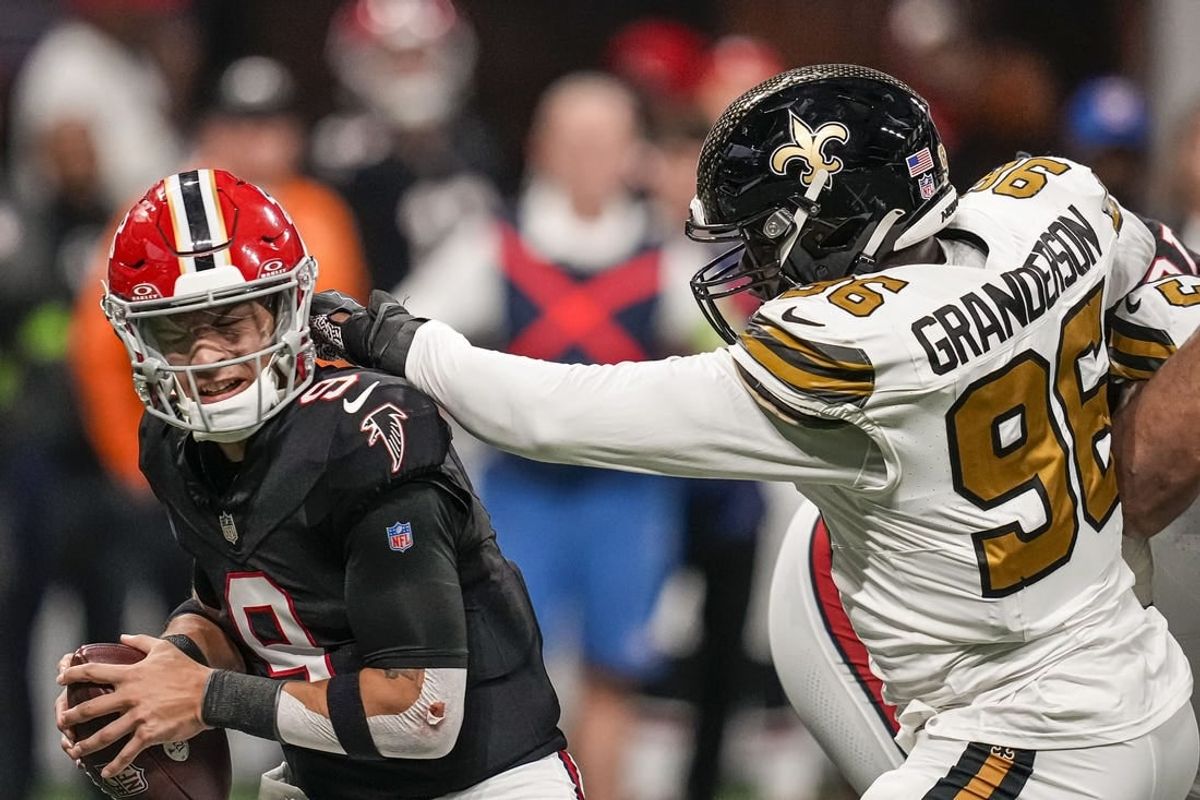 Nov 26, 2023; Atlanta, Georgia, USA; Atlanta Falcons quarterback Desmond Ridder (9) takes a hit from New Orleans Saints defensive end Carl Granderson (96) during the first half at Mercedes-Benz Stadium.