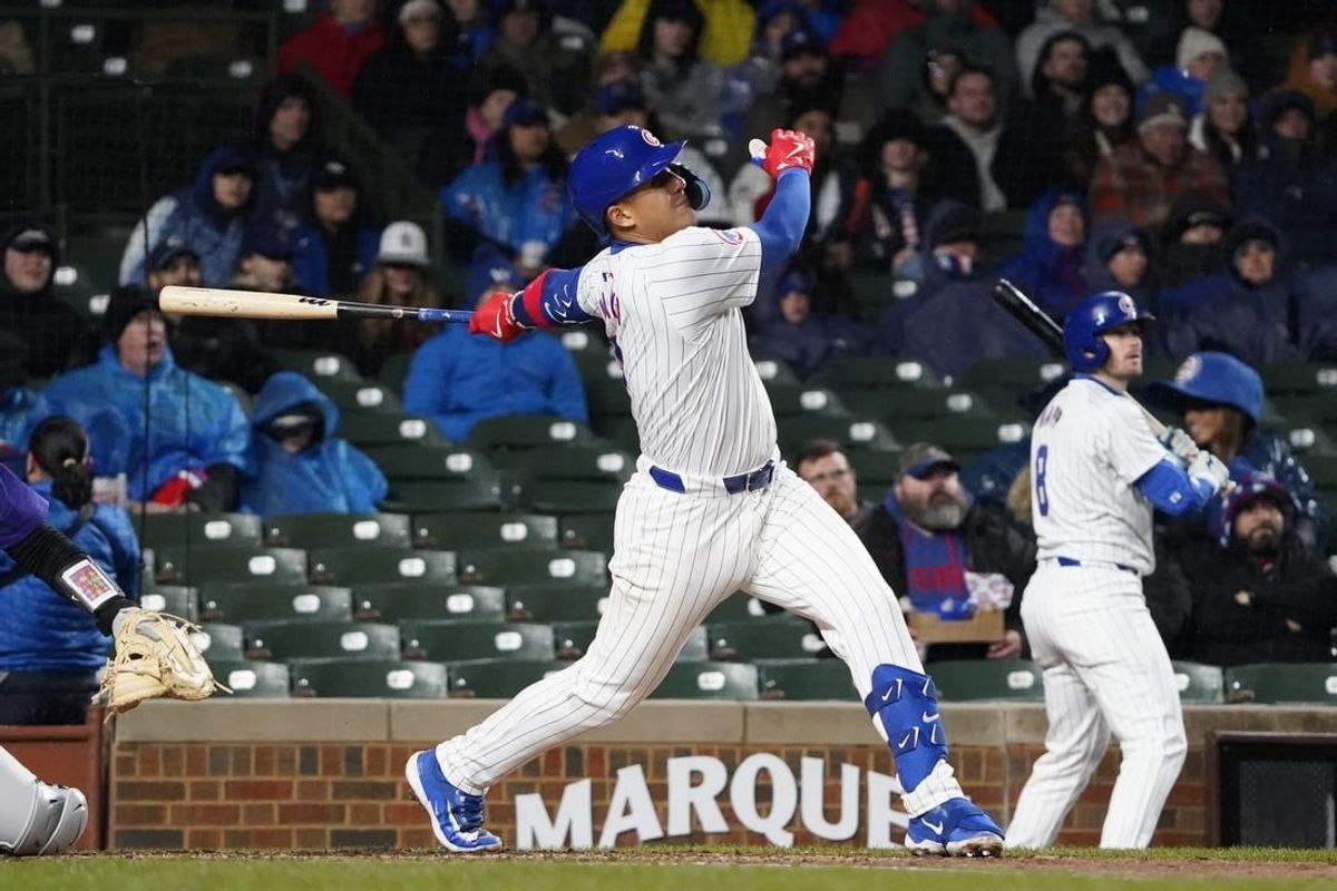 Apr 3, 2024; Chicago, Illinois, USA; Chicago Cubs catcher Miguel Amaya (9) hits a one run sacrifice fly against the Colorado Rockies during the second inning at Wrigley Field.