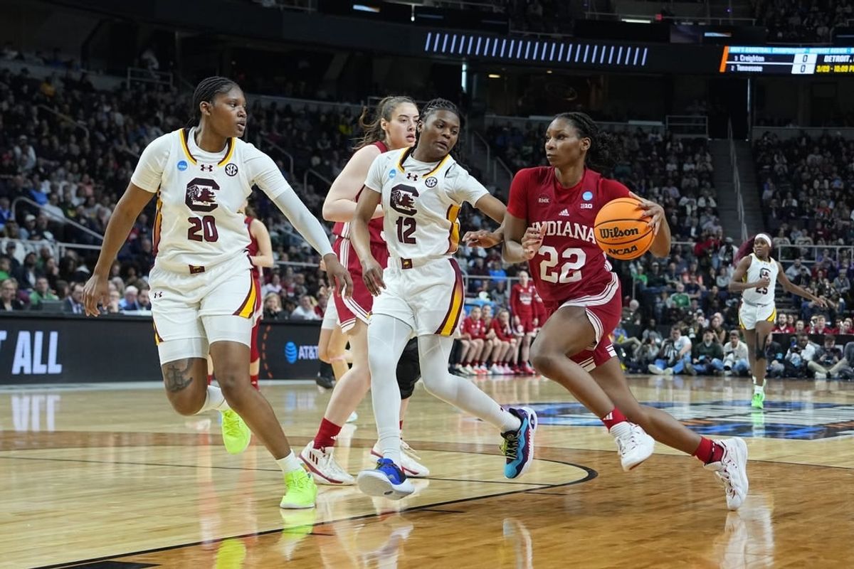 Mar 29, 2024; Albany, NY, USA; Indiana Hoosiers guard Chloe Moore-McNeil (22) drives the ball against South Carolina Gamecocks guard MiLaysia Fulwiley (12) and  forward Sania Feagin (20) during the first half in the semifinals of the Albany Regional of the 2024 NCAA Tournament at the MVP Arena at MVP Arena.