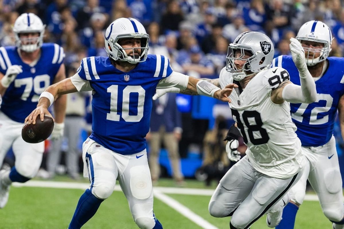 Dec 31, 2023; Indianapolis, Indiana, USA; Indianapolis Colts quarterback Gardner Minshew (10) looks to pass the ball while Las Vegas Raiders defensive end Maxx Crosby (98) defends  in the first half at Lucas Oil Stadium.