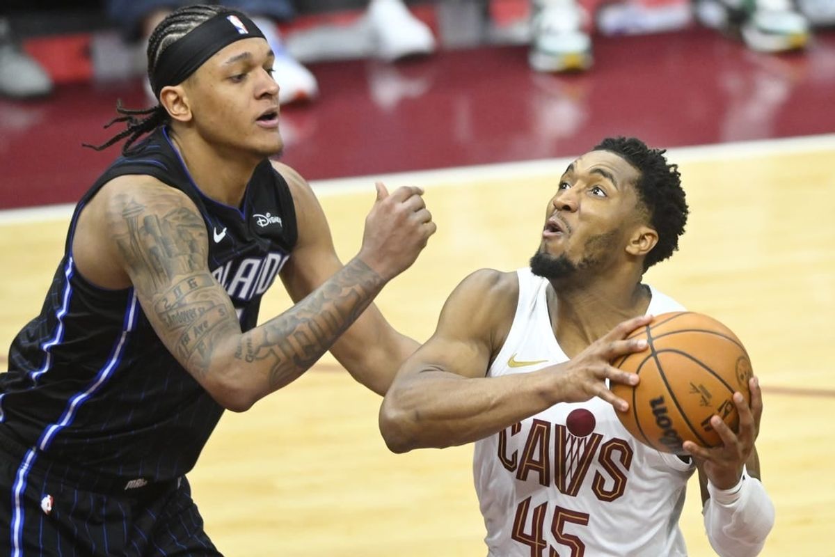 Apr 22, 2024; Cleveland, Ohio, USA; Cleveland Cavaliers guard Donovan Mitchell (45) drives against Orlando Magic forward Paolo Banchero (5) in the fourth quarter during game two of the first round of the 2024 NBA playoffs at Rocket Mortgage FieldHouse.