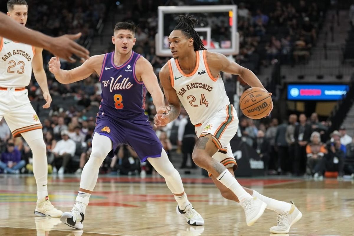 Mar 25, 2024; San Antonio, Texas, USA;  San Antonio Spurs guard Devin Vassell (24) drives past Phoenix Suns guard Grayson Allen (8) in the first half at Frost Bank Center.