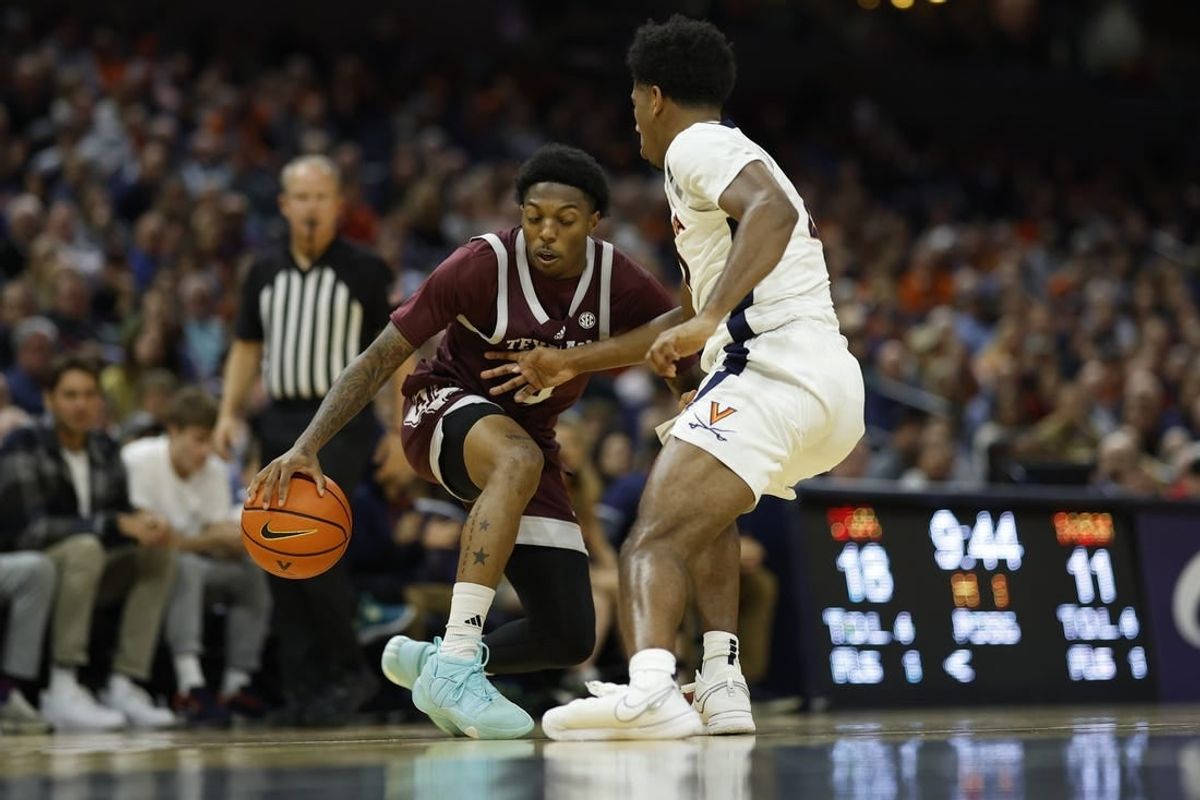 Nov 29, 2023; Charlottesville, Virginia, USA;  Texas A&M Aggies guard Wade Taylor IV (4) dribbles the ball as Virginia Cavaliers guard Reece Beekman (2) defends in the first half at John Paul Jones Arena.