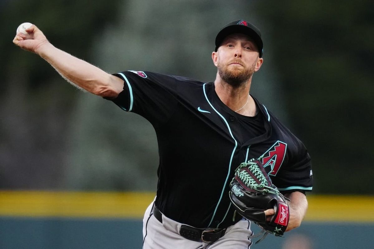 Apr 9, 2024; Denver, Colorado, USA; Arizona Diamondbacks starting pitcher Merrill Kelly (29) delivers a pitch in the first inning against the Colorado Rockies at Coors Field.