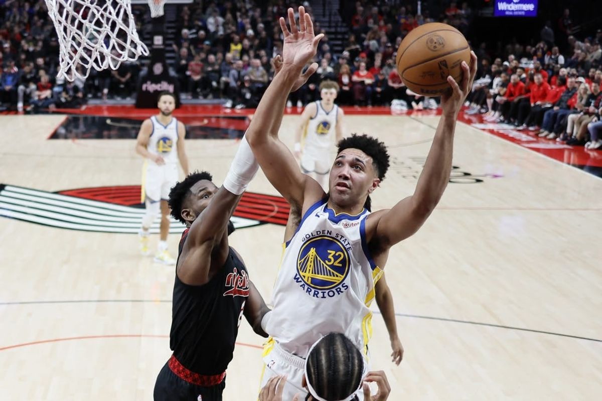 Dec 17, 2023; Portland, Oregon, USA; Golden State Warriors forward Trayce Jackson-Davis (32) shoots the ball over Portland Trail Blazers center Deandre Anton (2, left) during the second half at Moda Center.
