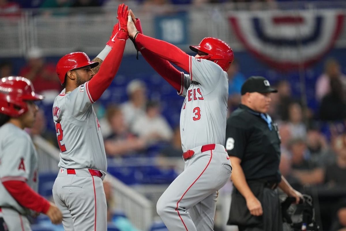 Apr 3, 2024; Miami, Florida, USA; Los Angeles Angels left fielder Taylor Ward (3) celebrates scoring a run with right fielder Aaron Hicks (12) in the third inning against the Miami Marlins at loanDepot Park.