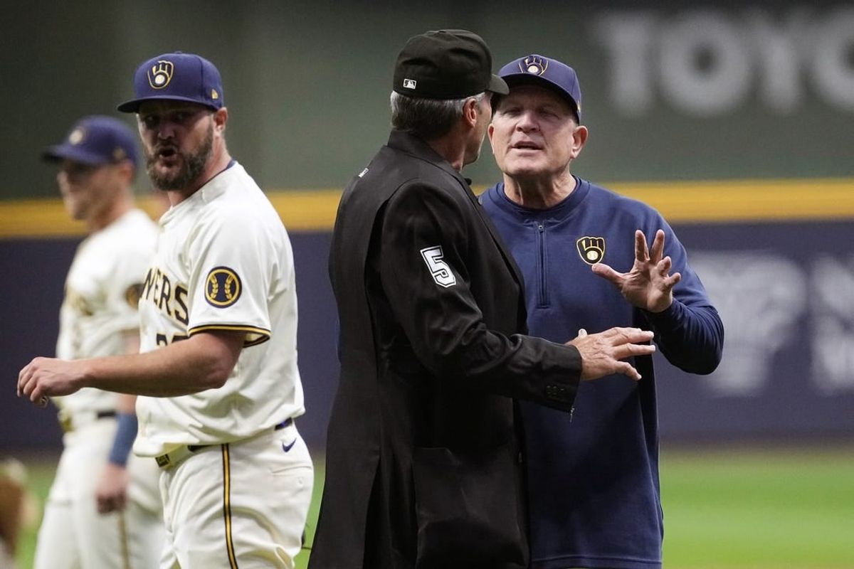 Apr 16, 2024; Milwaukee, Wisconsin, USA;  Milwaukee Brewers manager Pat Murphy (21) argues a call with home plate umpire Angel Hernandez (5) during the first inning against the San Diego Padres at American Family Field.