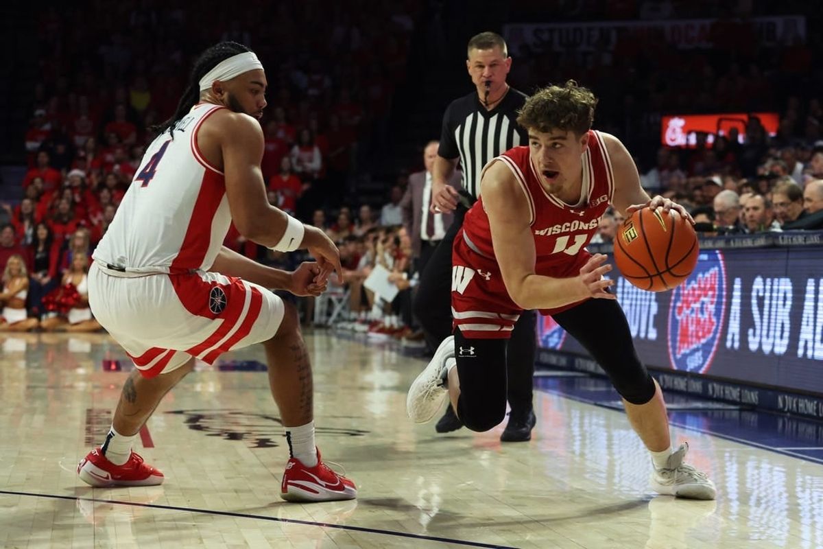 Dec 9, 2023; Tucson, Arizona, USA; Wisconsin Badgers guard Max Klesmit (11) drives to the net against Arizona Wildcats guard Kylan Boswell (4) during the first half at McKale Center.