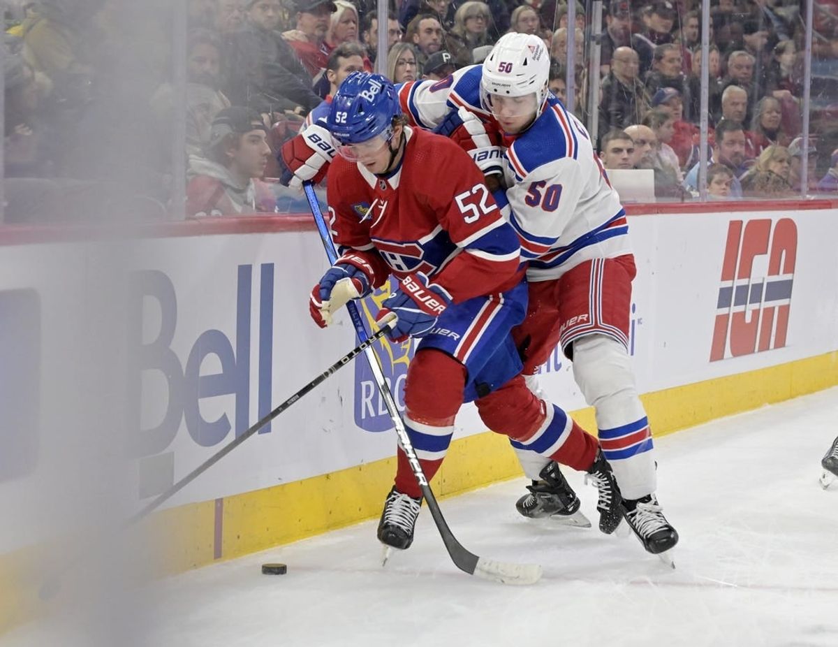 Jan 6, 2024; Montreal, Quebec, CAN; Montreal Canadiens defenseman Justin Barron (52) plays the puck and New York Rangers forward Will Cuylle (50) forechecks during the first period at the Bell Centre.