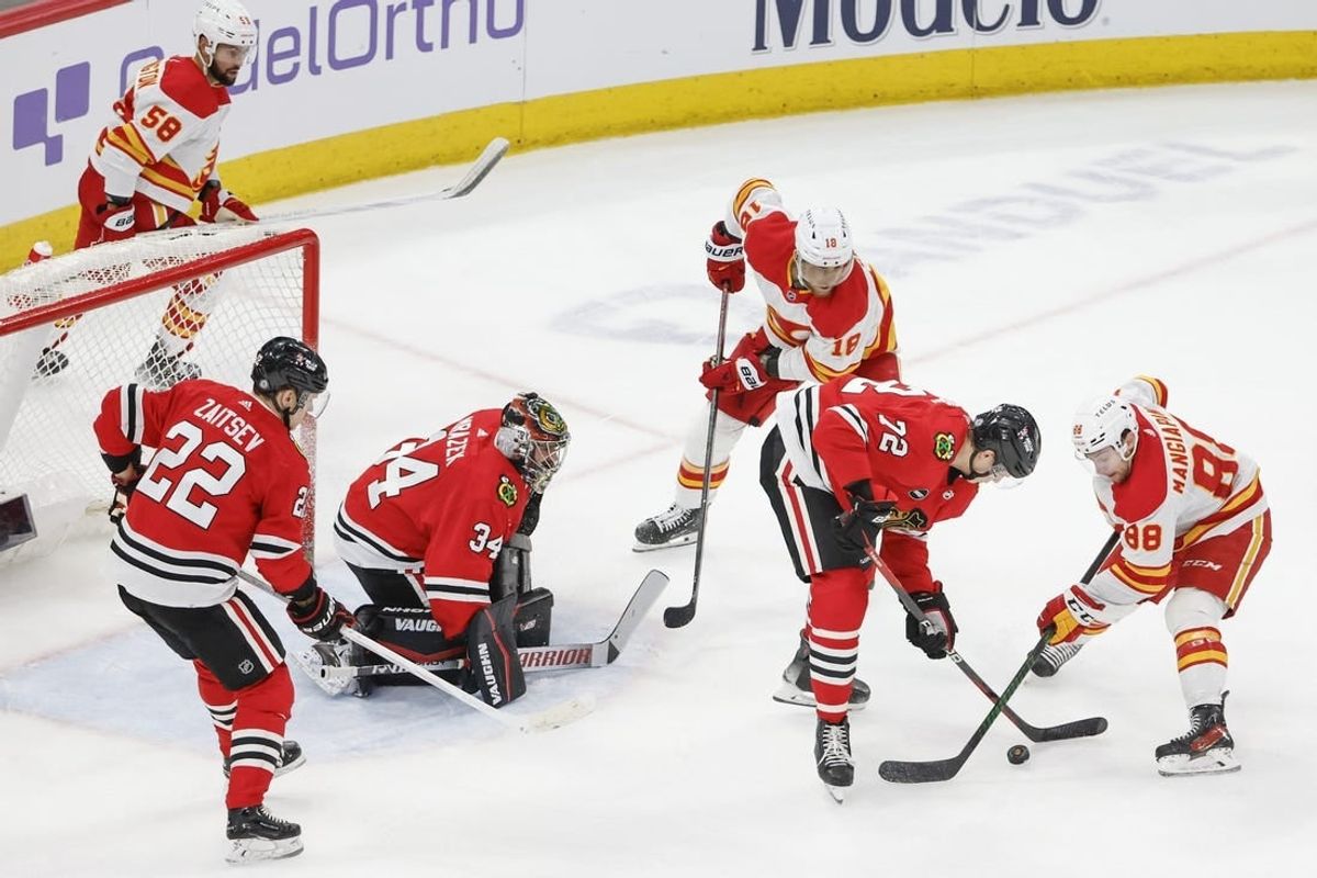 Mar 26, 2024; Chicago, Illinois, USA; Chicago Blackhawks defenseman Alex Vlasic (72) battles for the puck with Calgary Flames left wing Andrew Mangiapane (88) during the second period at United Center.