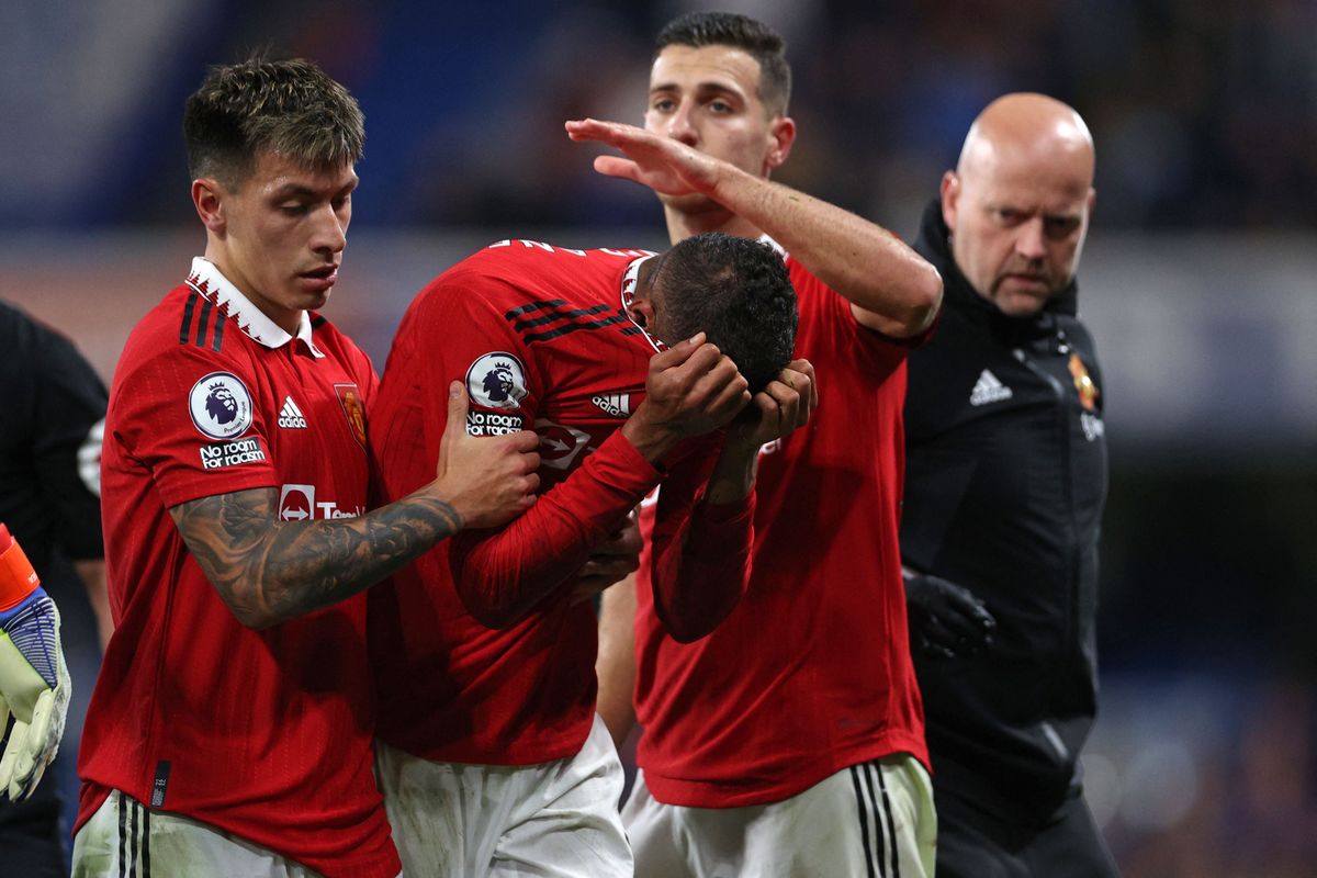 Varane (center) is helped up by his teammates.