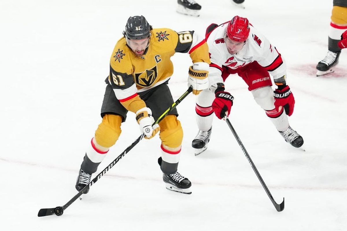 Feb 17, 2024; Las Vegas, Nevada, USA; Vegas Golden Knights right wing Mark Stone (61) skates against Carolina Hurricanes defenseman Dmitry Orlov (7) during the third period at T-Mobile Arena.