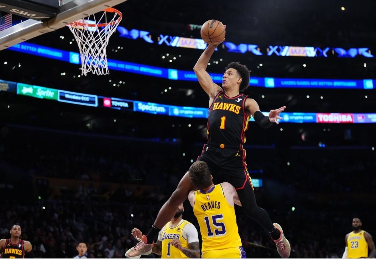 Mar 18, 2024; Los Angeles, California, USA; Atlanta Hawks forward Jalen Johnson (1) dunks the ball over Los Angeles Lakers guard Austin Reaves (15) in the first half at Crypto.com Arena.