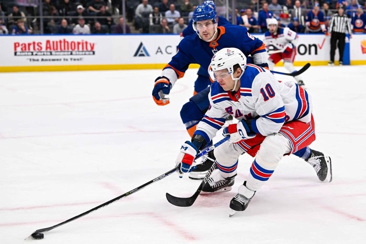 Apr 9, 2024; Elmont, New York, USA; New York Rangers left wing Artemi Panarin (10) attempts to control the puck defended by New York Islanders defenseman Ryan Pulock (6) during the third period at UBS Arena.