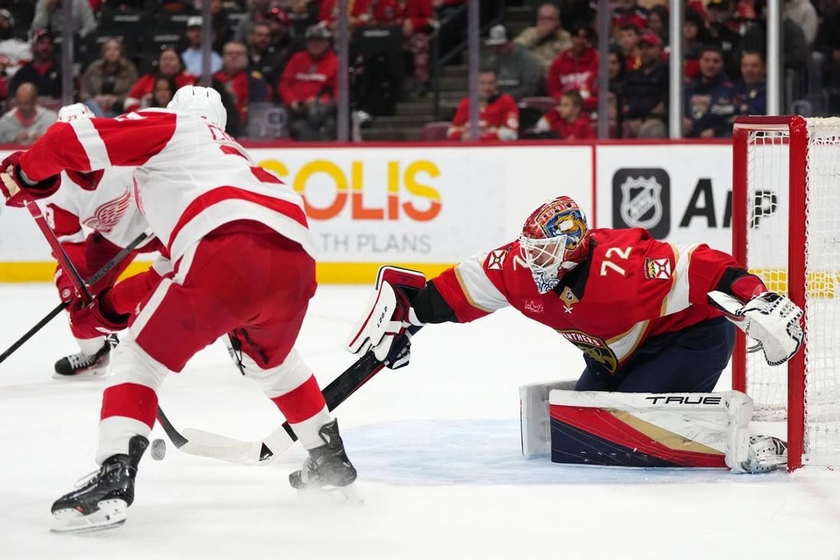Jan 17, 2024; Sunrise, Florida, USA; Florida Panthers goaltender Sergei Bobrovsky (72) knocks the puck away from Detroit Red Wings left wing J.T. Compher (37) during the first period at Amerant Bank Arena.