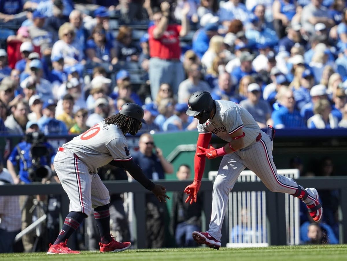 Mar 28, 2024; Kansas City, Missouri, USA; Minnesota Twins third baseman Royce Lewis (23) celebrates with third base coach Tommy Watkins after hitting a home run during the first inning against the Kansas City Royals at Kauffman Stadium.