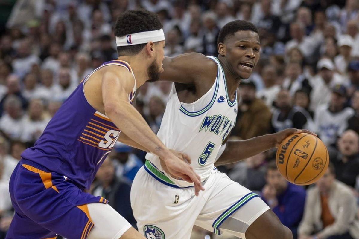 Apr 20, 2024; Minneapolis, Minnesota, USA; Minnesota Timberwolves guard Anthony Edwards (5) dribbles the ball around Phoenix Suns guard Devin Booker (1) in the second half during game one of the first round for the 2024 NBA playoffs at Target Center.