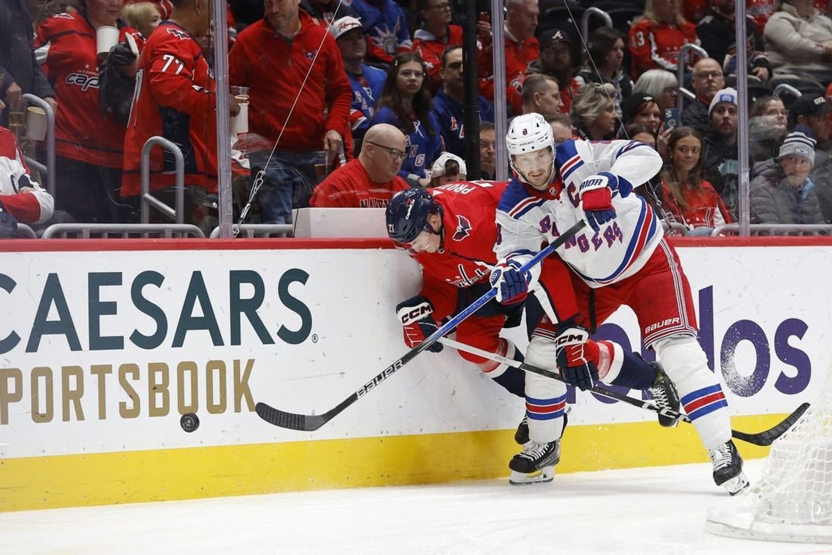 Jan 13, 2024; Washington, District of Columbia, USA; Washington Capitals center Aliaksei Protas (21) and New York Rangers defenseman Jacob Trouba (8) battle for the puck in the first period at Capital One Arena.