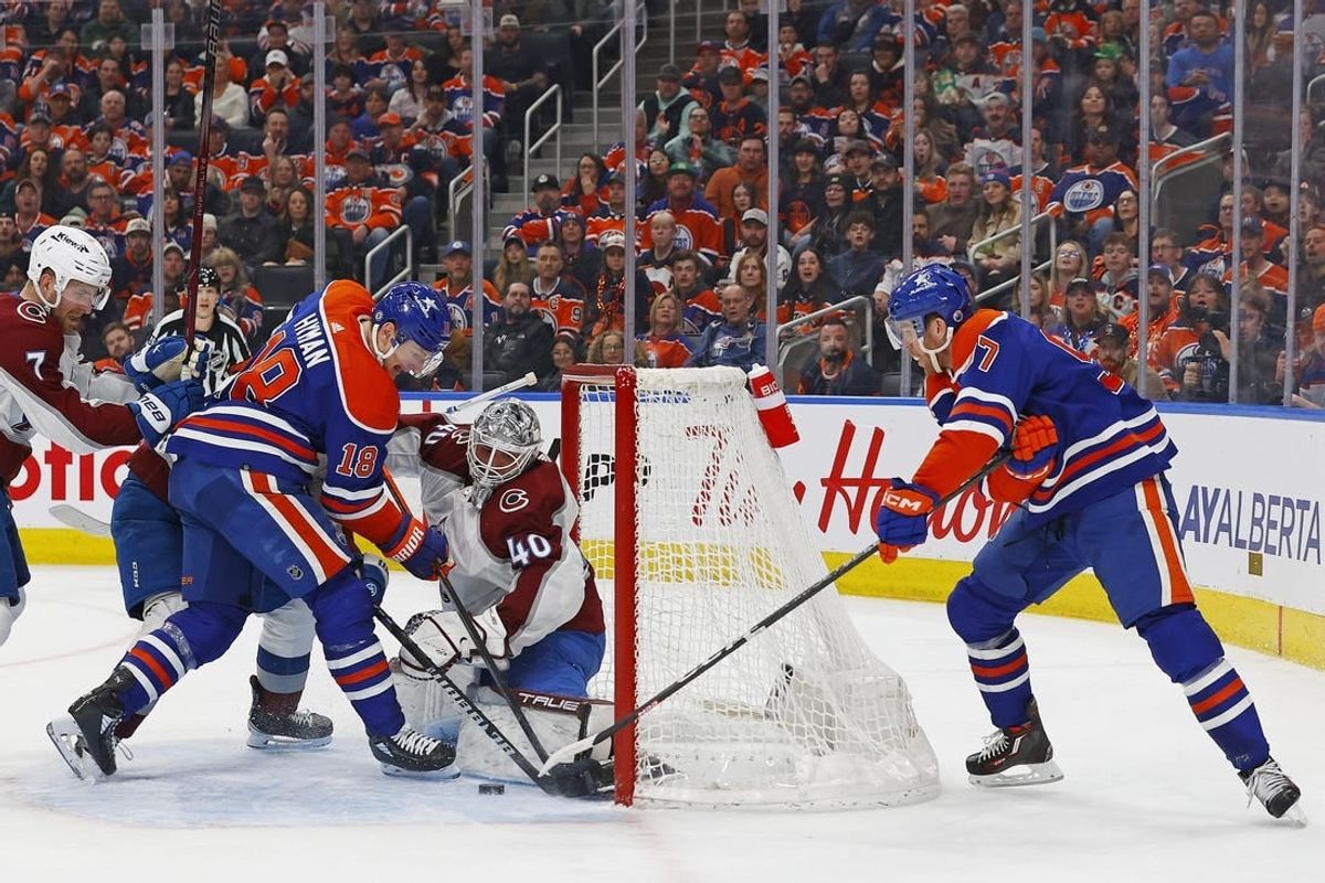 Mar 16, 2024; Edmonton, Alberta, CAN; Edmonton Oilers forward Connor McDavid (97) and forward Zach Hyman (18) try to jam a loose puck past Colorado Avalanche goaltender Alexander Georgiev (40) during the first period at Rogers Place.