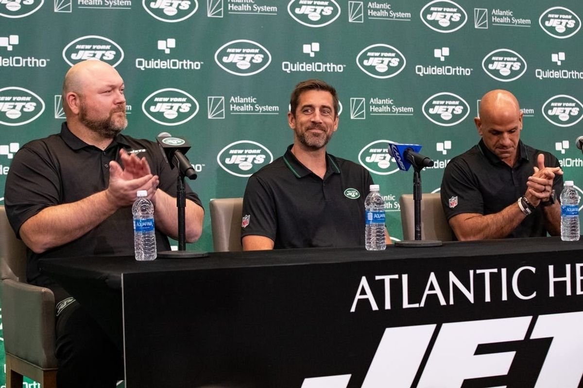 Apr 26, 2023; Florham Park, NJ, USA; New York Jets quarterback Aaron Rodgers (8) (center) is introduced during the introductory press conference alongside general manager Joe Douglas (left) and head coach Robert Saleh (right) at Atlantic Health Jets Training Center.