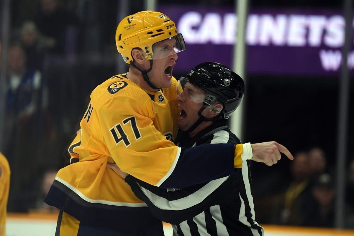 Dec 19, 2023; Nashville, Tennessee, USA; Nashville Predators right wing Michael McCarron (47) is held back by linesman Libor Suchanek (60) before receiving a game misconduct during the first period against the Vancouver Canucks at Bridgestone Arena.