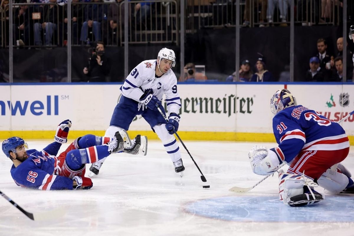 Dec 12, 2023; New York, New York, USA; Toronto Maple Leafs center John Tavares (91) skates with the puck against New York Rangers defenseman Erik Gustafsson (56) and goaltender Igor Shesterkin (31) during the third period at Madison Square Garden.