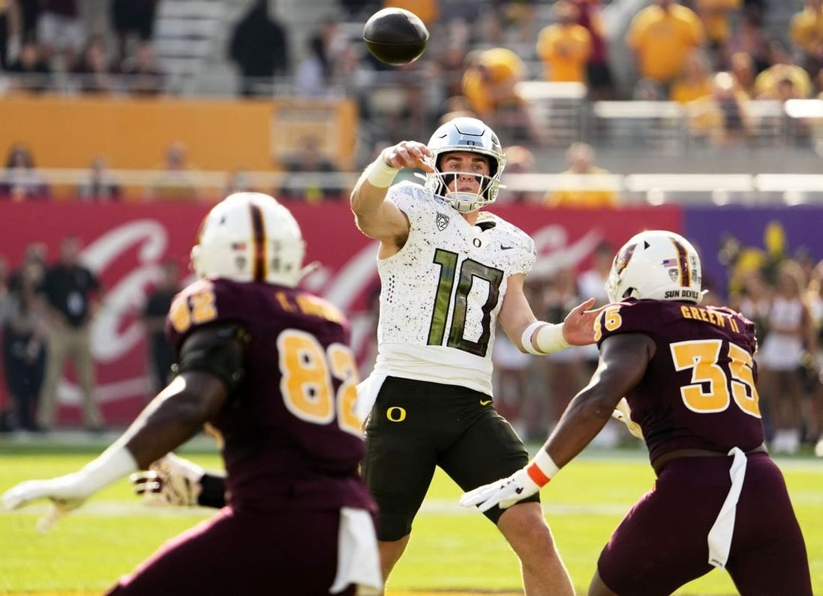 Nov 18, 2023; Tempe, Arizona, USA; Oregon Ducks quarterback Bo Nix (10) throws a touchdown pass with pressure from Arizona State Sun Devils defensive lineman B.J. Green II (35) in the first half at Mountain America Stadium.