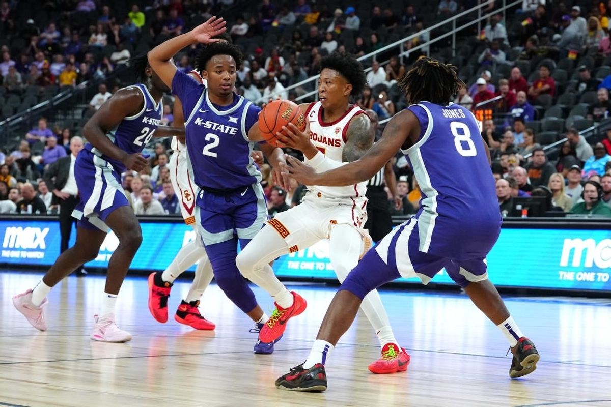 Nov 6, 2023; Las Vegas, Nevada, USA; USC Trojans guard Boogie Ellis (5) passes the ball between Kansas State Wildcats guard Tylor Perry (2) and Kansas State Wildcats guard R.J. Jones (8) during the first half at T-Mobile Arena.