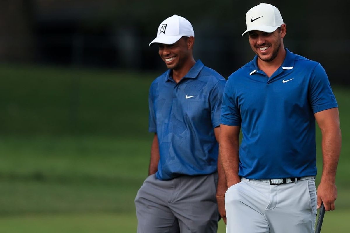 Jul 17, 2020; Dublin, Ohio, USA; Tiger Woods (left) walks with Brooks Koepka (right) towards the 13th green during the second round of The Memorial Tournament at Muirfield Village Golf Club.