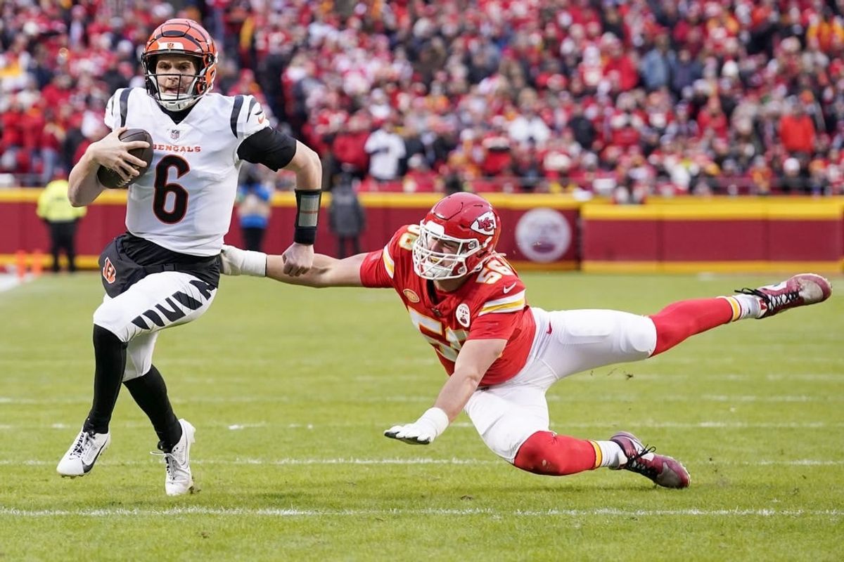 Dec 31, 2023; Kansas City, Missouri, USA; Cincinnati Bengals quarterback Jake Browning (6) runs the ball as Kansas City Chiefs defensive end George Karlaftis (56) misses the tackle during the first half at GEHA Field at Arrowhead Stadium.