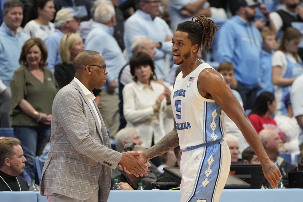 Nov 6, 2023; Chapel Hill, North Carolina, USA; North Carolina Tar Heels forward Armando Bacot (5) shakes hands with head coach Hubert Davis leaving the court in the second half at Dean E. Smith Center.