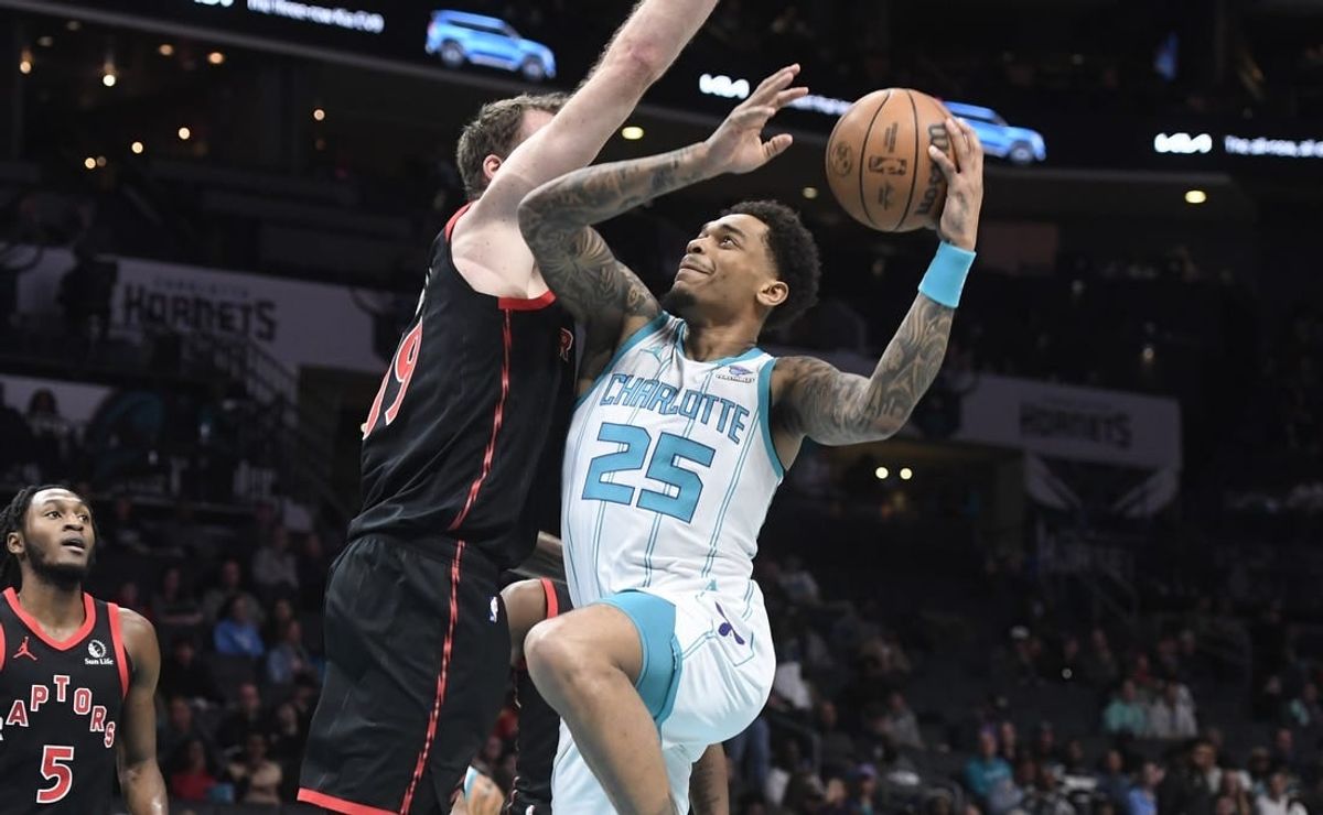 Feb 7, 2024; Charlotte, North Carolina, USA; Charlotte Hornets forward center P.J. Washington Jr. (25) drives in past Toronto Raptors center Jakob Poeltl (19) during the first half at the Spectrum Center.