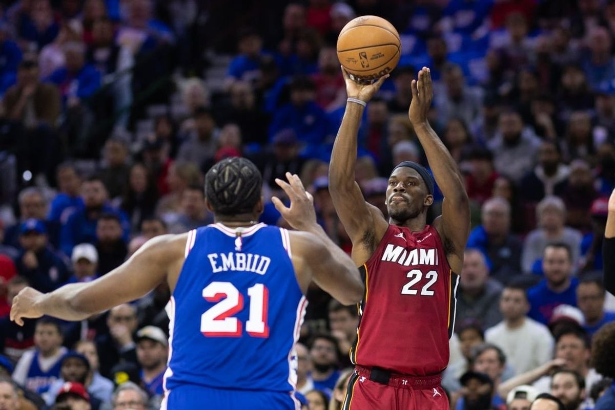 Apr 17, 2024; Philadelphia, Pennsylvania, USA; Miami Heat forward Jimmy Butler (22) shoots past Philadelphia 76ers center Joel Embiid (21) during the second quarter of a play-in game of the 2024 NBA playoffs at Wells Fargo Center.