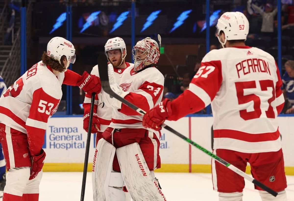 Apr 1, 2024; Tampa, Florida, USA; Detroit Red Wings goaltender Alex Lyon (34) celebrates with defenseman Moritz Seider (53), left wing David Perron (57) after they beat the Tampa Bay Lightning at Amalie Arena.