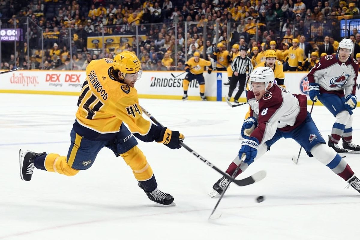Mar 2, 2024; Nashville, Tennessee, USA; Nashville Predators left wing Kiefer Sherwood (44) shoots the puck against Colorado Avalanche defenseman Cale Makar (8) during the first period at Bridgestone Arena.