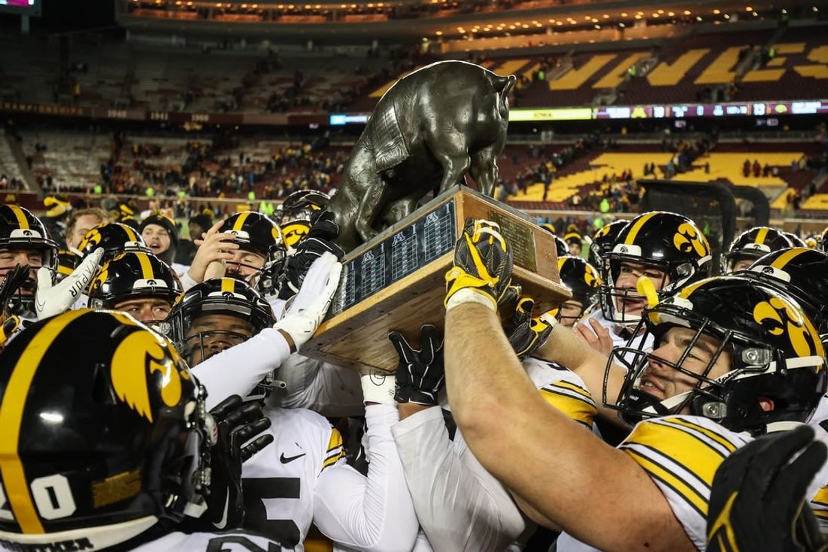Nov 19, 2022; Minneapolis, Minnesota, USA; Iowa Hawkeyes players celebrate with the Floyd of Rosedale after defeating the Minnesota Golden Gophers at Huntington Bank Stadium.