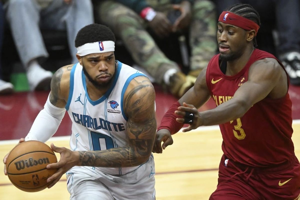 Mar 25, 2024; Cleveland, Ohio, USA; Charlotte Hornets forward Miles Bridges (0) looks to pass beside Cleveland Cavaliers guard Caris LeVert (3) in the fourth quarter at Rocket Mortgage FieldHouse.